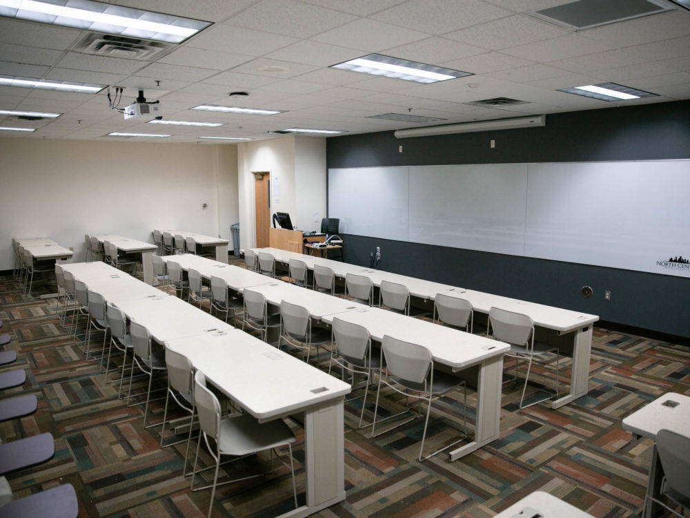 Empty Phillipps Hall classroom with whiteboard and tables