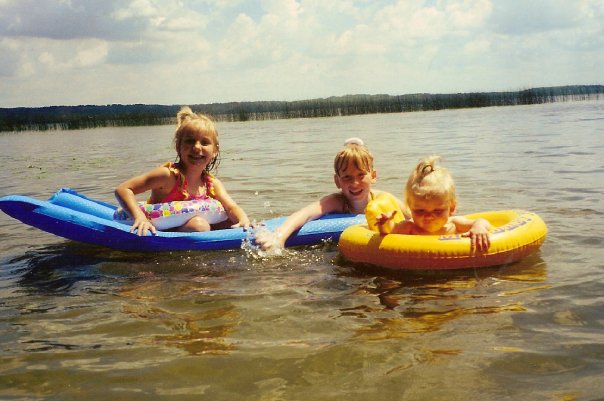 three kids in lake in floaties