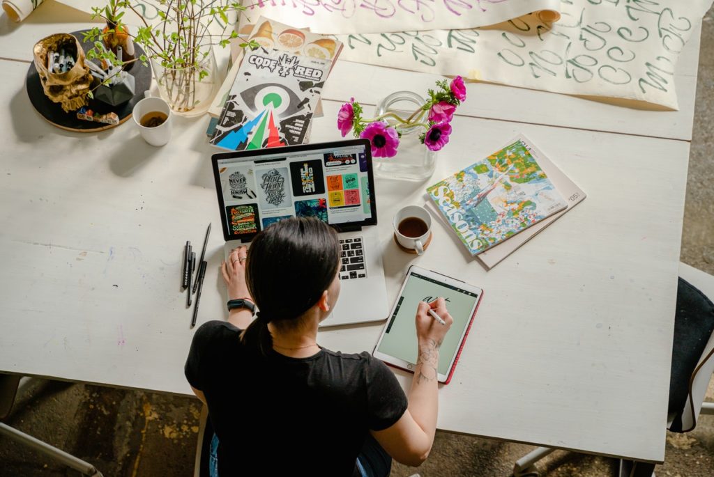 Woman sitting at a desk working on iPad