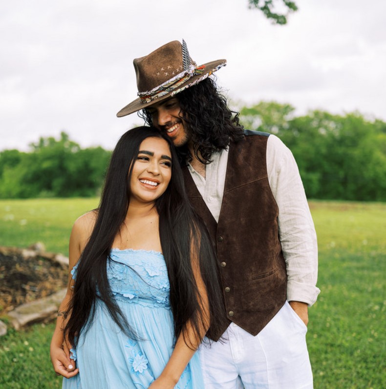 Edgar and Courtnie Aguilar stand next to each other lovingly and pose for a photo